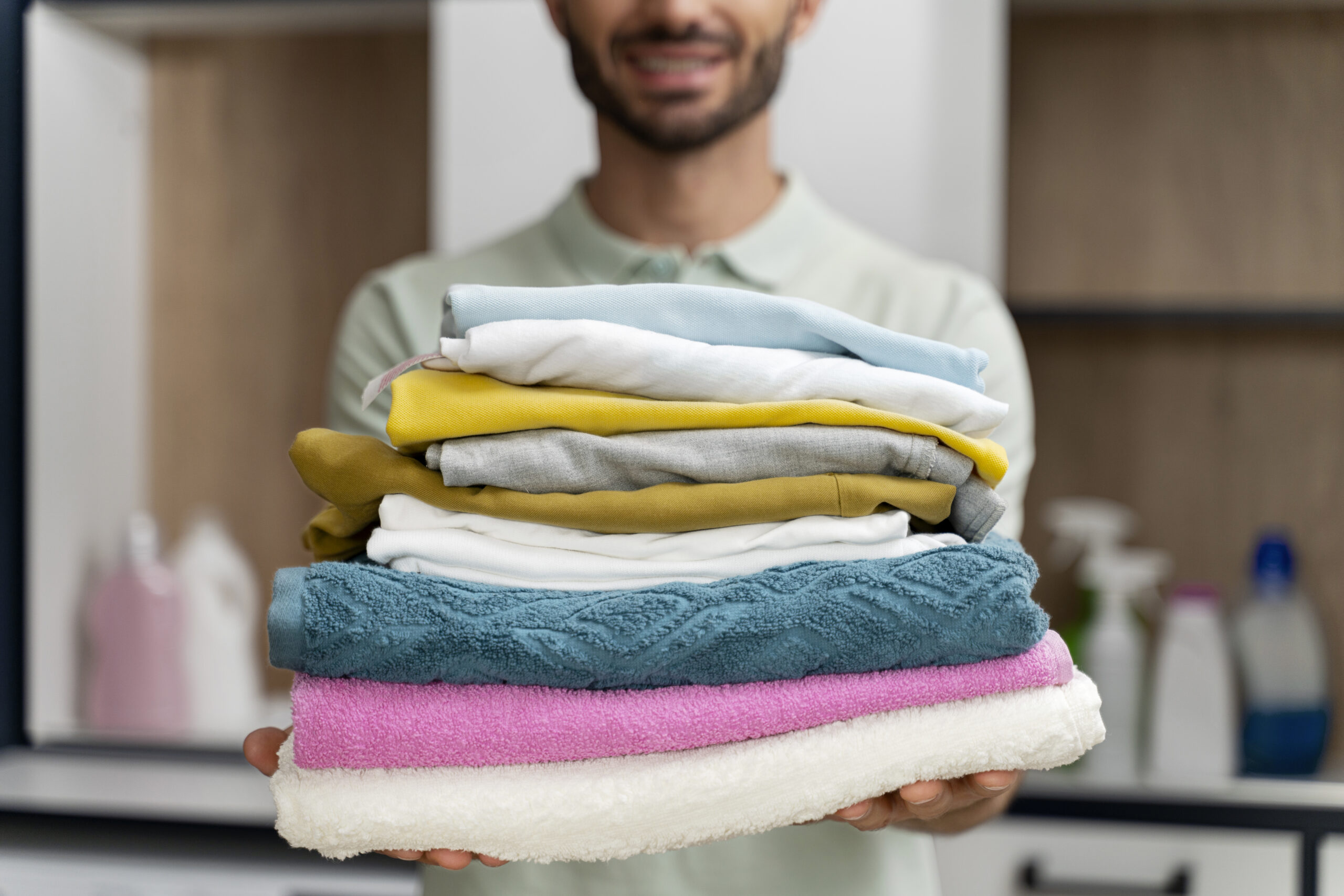 man-holding-pile-clean-clothes