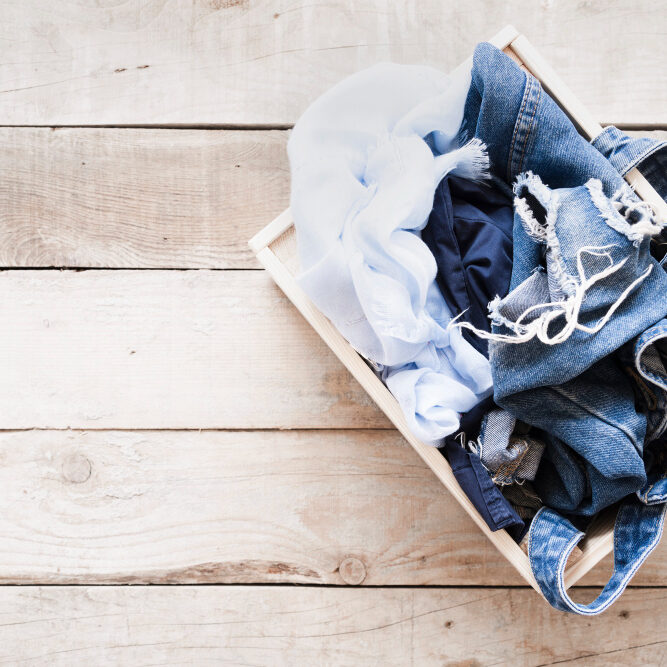 top-view-full-laundry-basket-with-wooden-background